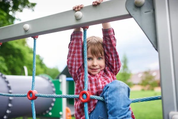 Offering daily and weekly programs to encourage curiosity, creativity, enthusiasm, problem solving and experimentation. Child playing in the park.